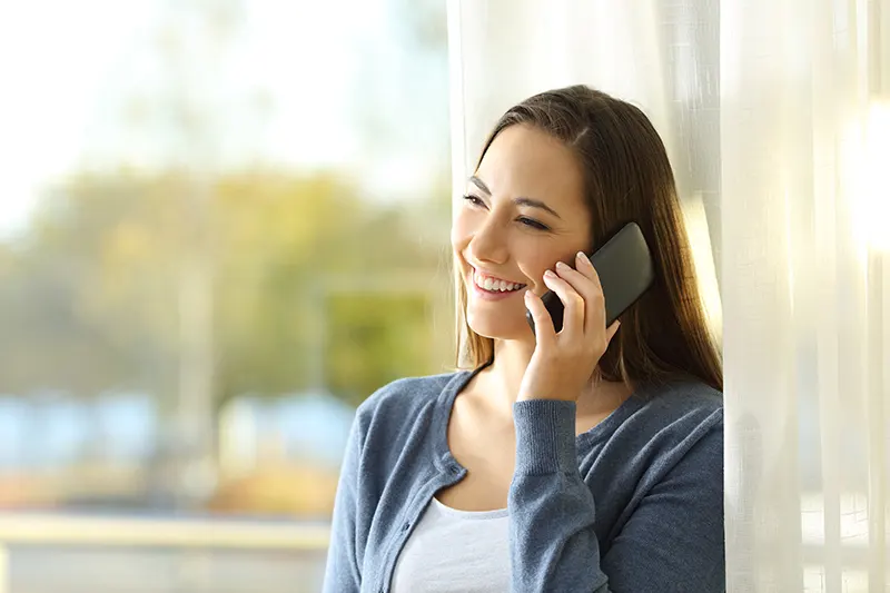 a happy woman talking on the phone