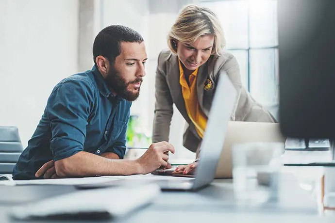 Professional man and woman working together on a computer