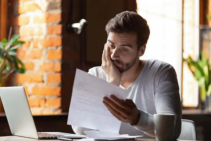 Man looking at paper in distress